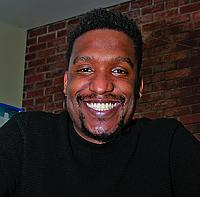 Headshot of Marc Thurman, a Black male with mustache and goatee, smiling at the camera