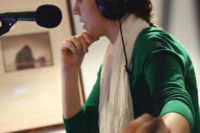 图为一名学生在WLMC广播电台演播室制作广播节目.
