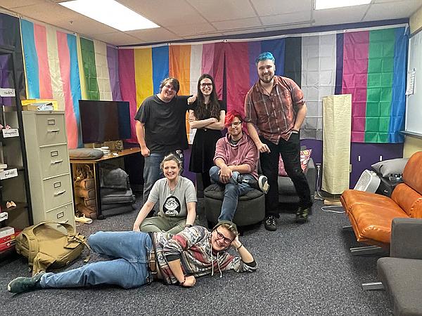 Six students posing 为 a photo in the Stonewall Center room.